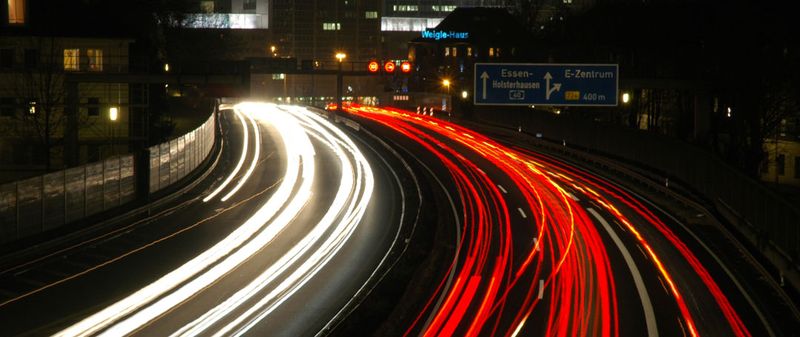 Lichtspuren des Verkehrs bei Nacht als Sinnbild für Tempo und Belastung im Berufsalltag